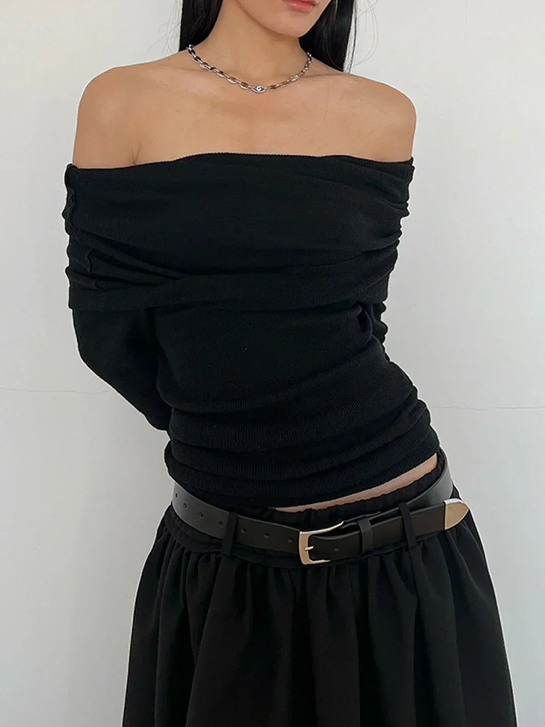 Top de manga larga y hombros descubiertos.